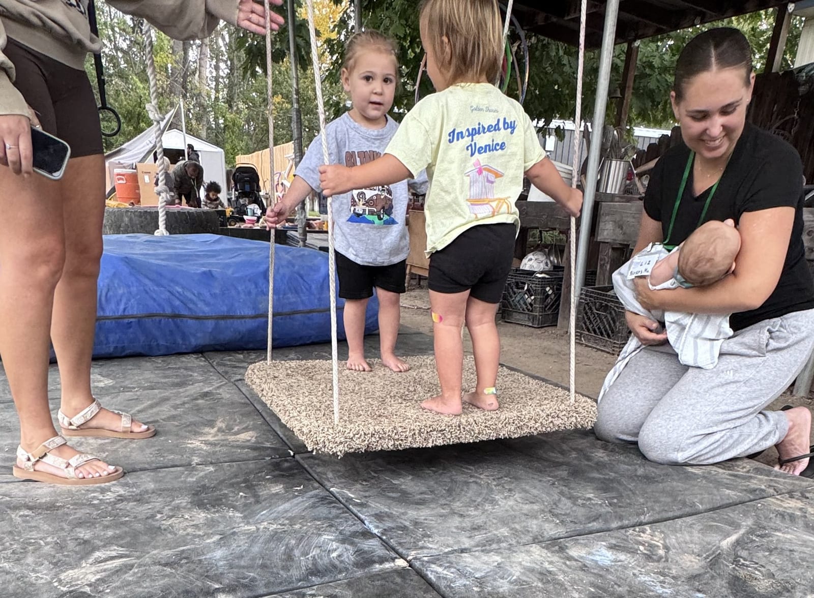 Caregivers staying close as children explore a suspended play platform