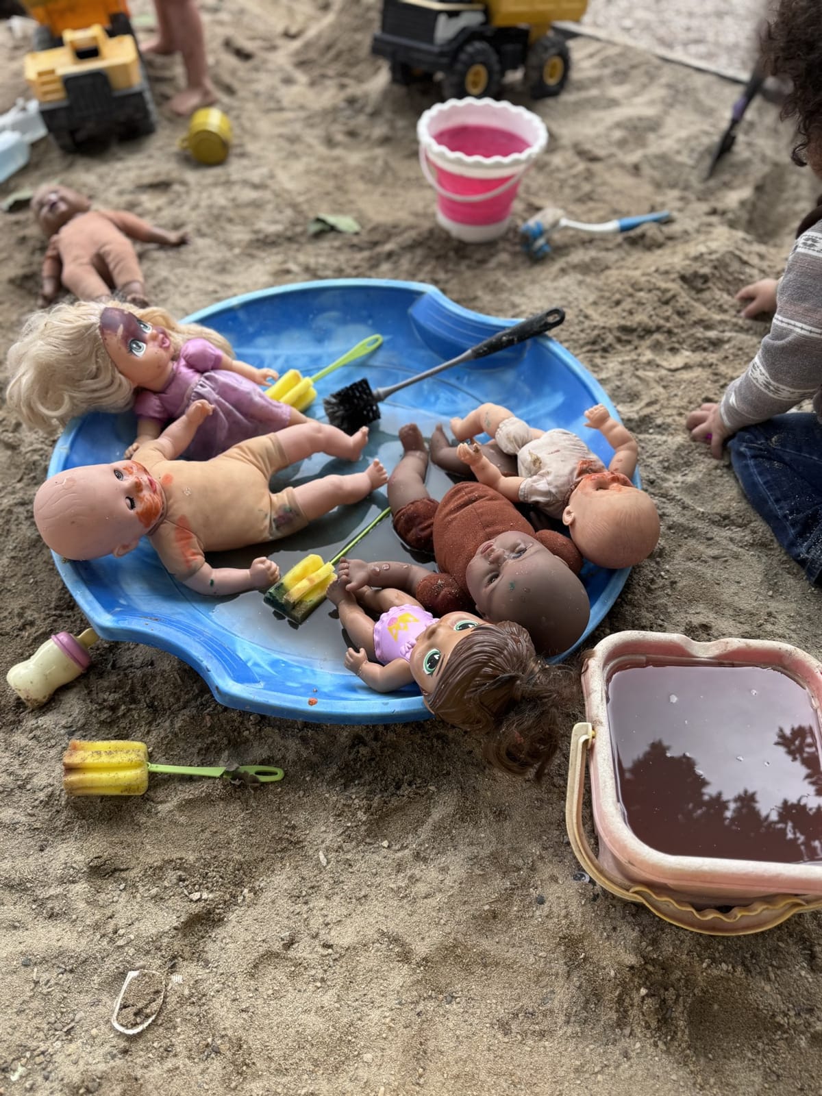 Dolls and water trays ready for imaginative outdoor play